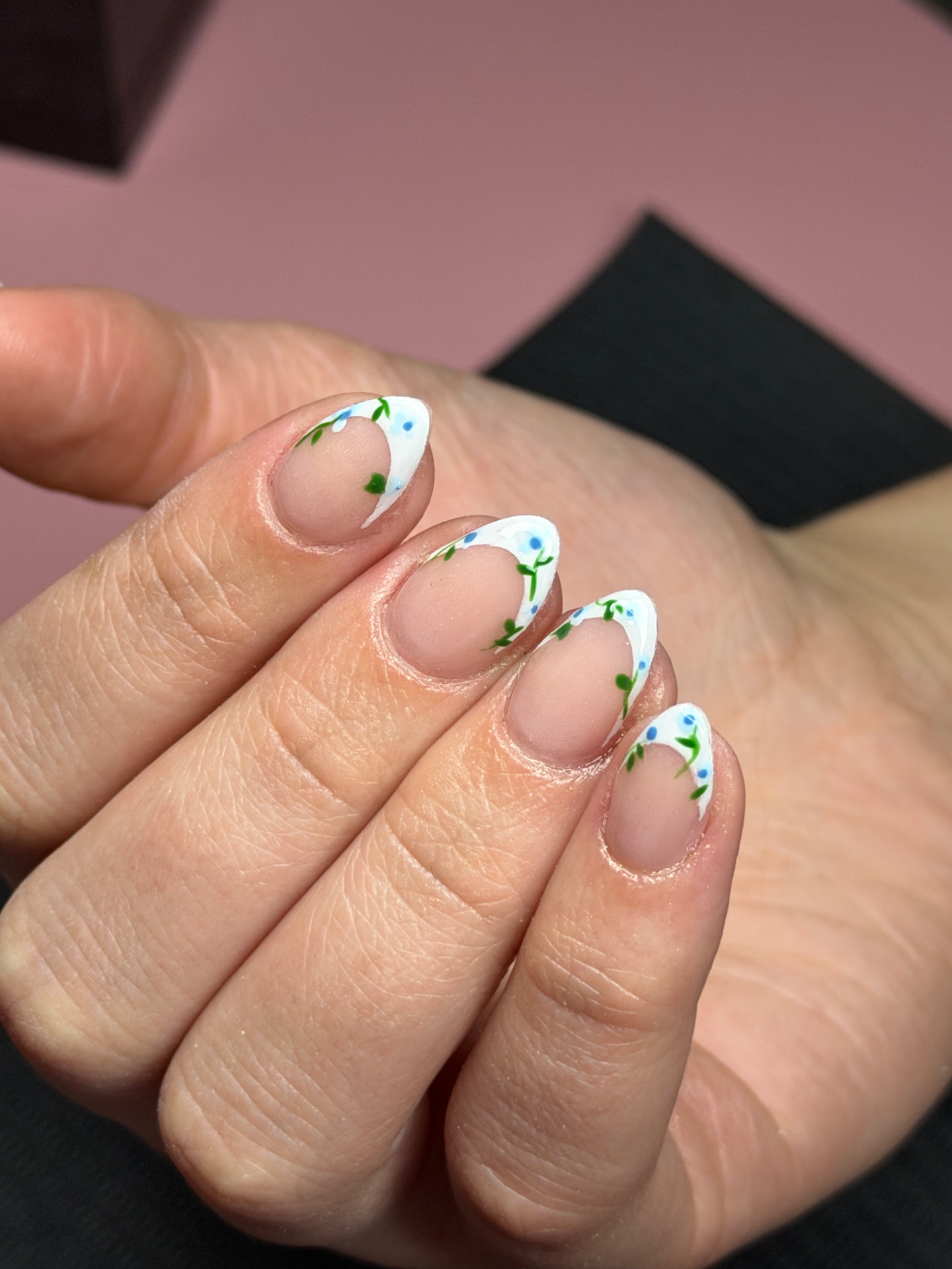 White French tips with hand-painted blue flowers and vines by Serin